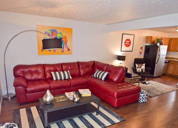 A red leather couch with a coffee table in front of it.