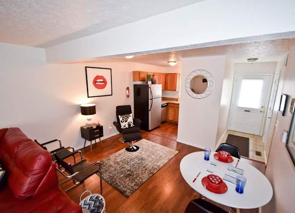 A living room with a red couch and a white table.