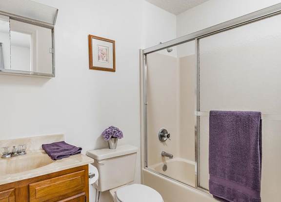 A bathroom with a toilet, sink, and shower.