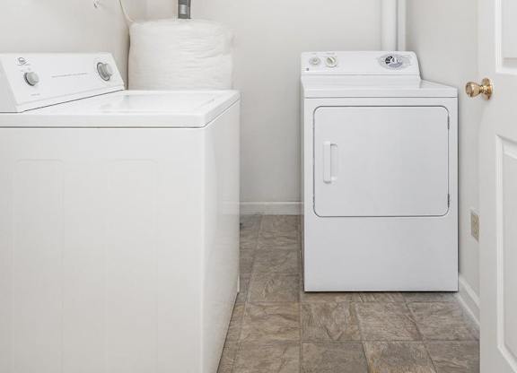 A white washing machine and dryer in a small laundry room.