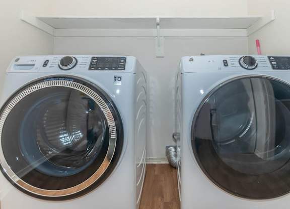 Two front load washing machines in a laundry room.