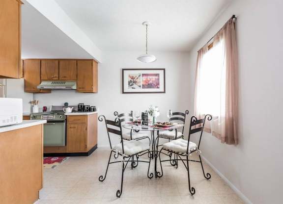A kitchen with a dining table set for four.