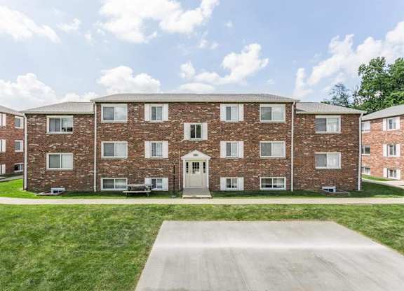 A large brick building with a driveway in front.