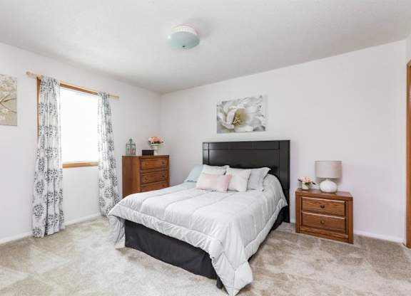A bedroom with a large bed, nightstands, and a painting on the wall.