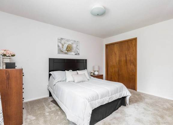 A bedroom with a large bed and a wooden door.