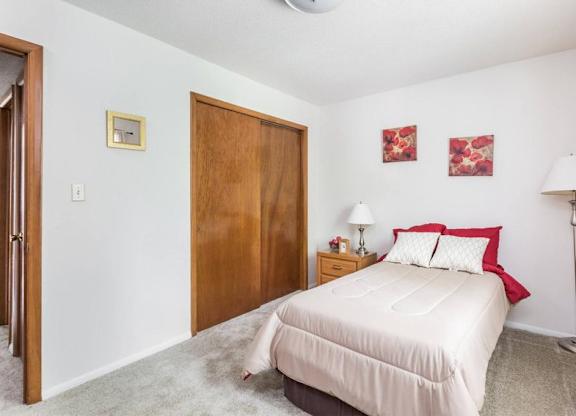 A bedroom with a bed, nightstand, and lamp.