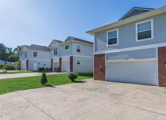 A row of houses with a driveway in front.