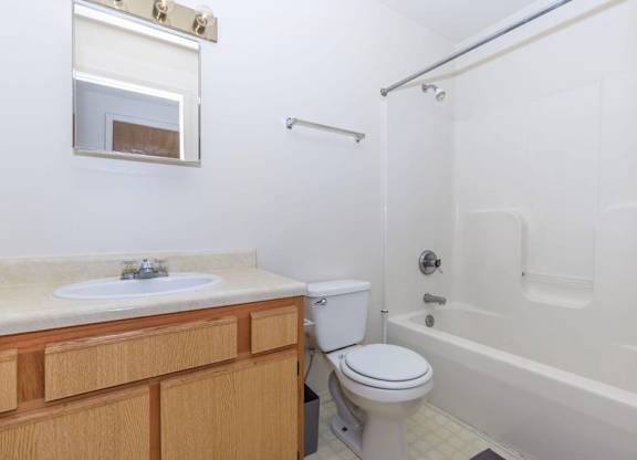 A white bathroom with a toilet, sink, and bathtub.
