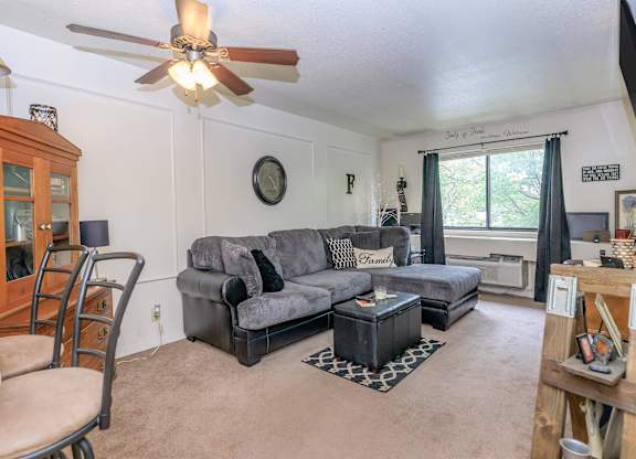A living room with a grey couch and a wooden cabinet.