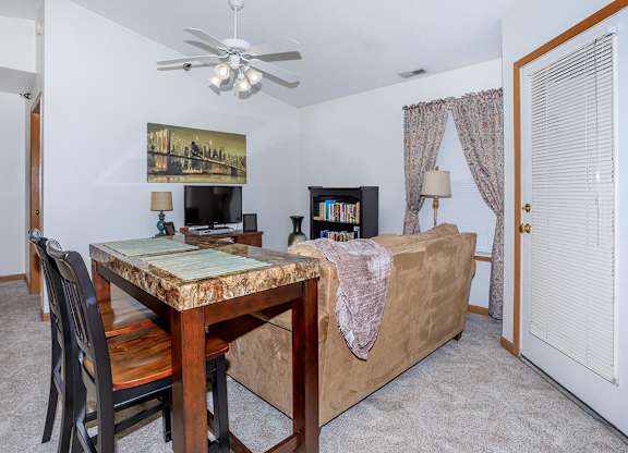 A room with a table, chairs, and a bed.