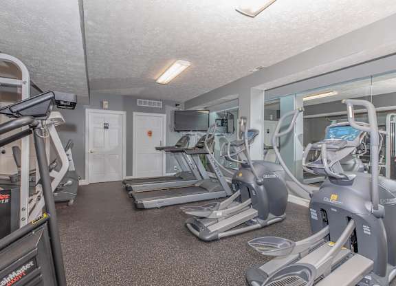 A gym with treadmills and elliptical machines.
