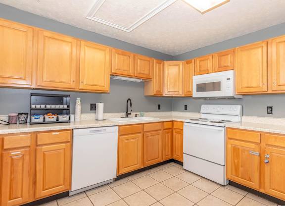 A kitchen with wooden cabinets and white appliances.