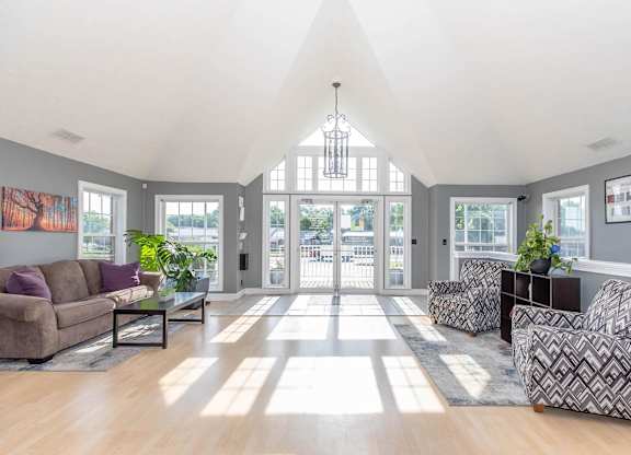 A sunny day in a spacious living room with a couch, chairs, and a coffee table.