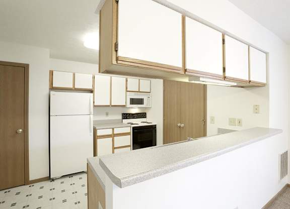 A kitchen with white appliances and a white counter top.