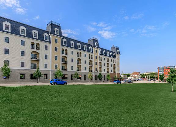 A large building with a green lawn in front of it.