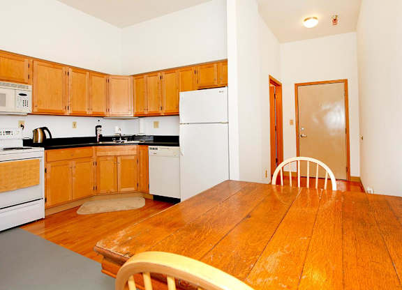 A kitchen with wooden cabinets and a white refrigerator.