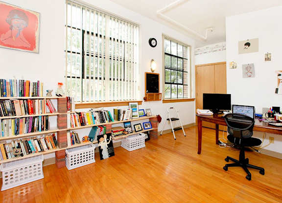 A room with a bookshelf, a desk, and a chair.