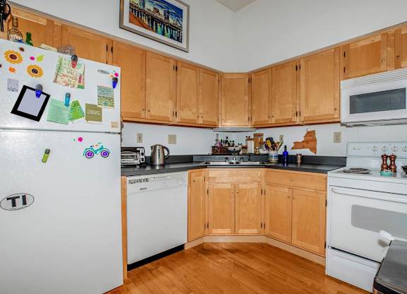 A kitchen with wooden cabinets and white appliances.
