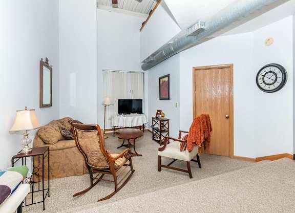 A living room with a couch, chair, and a fireplace.