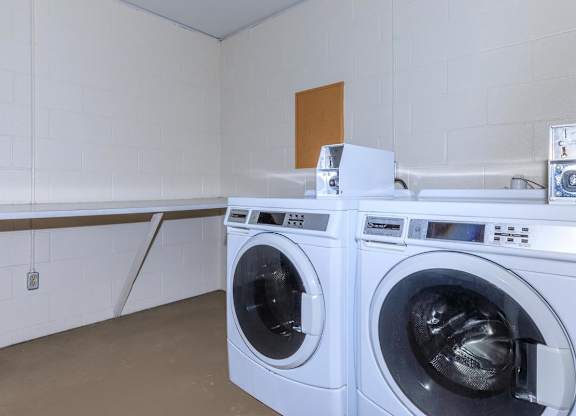 Two front load washing machines in a laundry room.