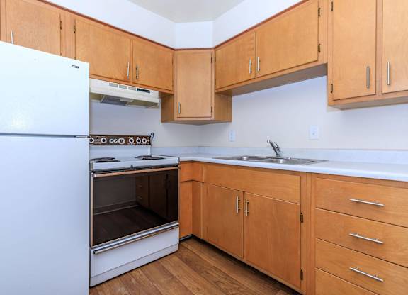 A kitchen with wooden cabinets and a white refrigerator.