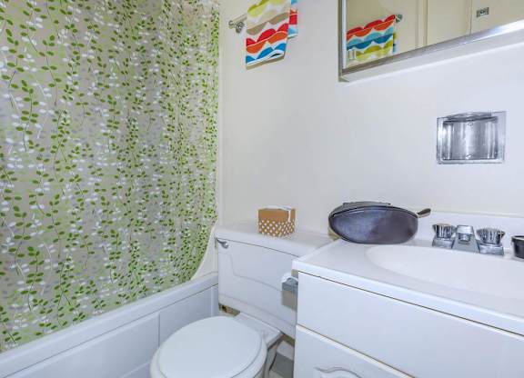 A white toilet sits next to a white sink in a bathroom.