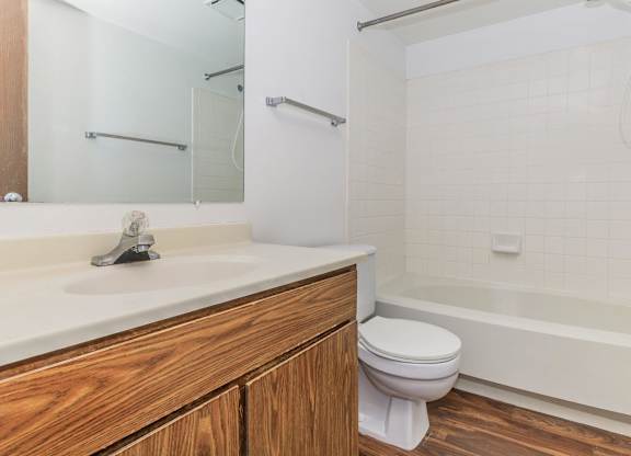 A white sink with a silver faucet and a white toilet in a bathroom.