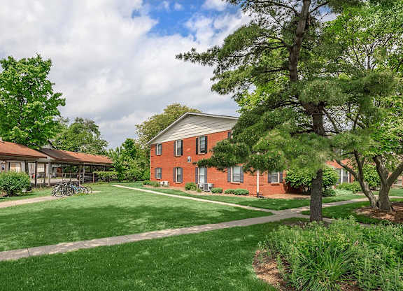 A red brick building with a green lawn in front.
