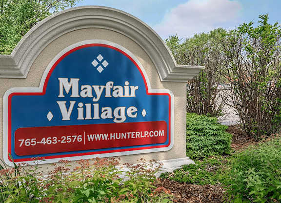 A sign for Mayfair Village with a phone number and website.