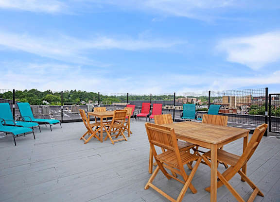 A wooden table and chairs are set up on a wooden deck.