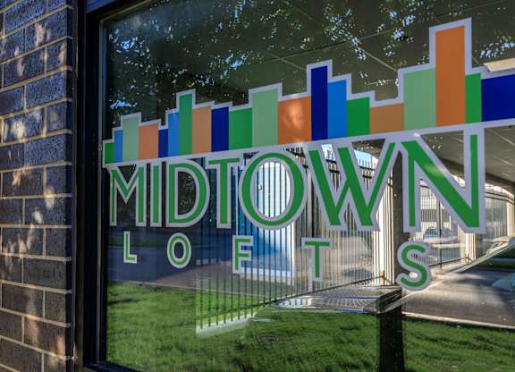 A window with a sign that says Midtown Lofts.
