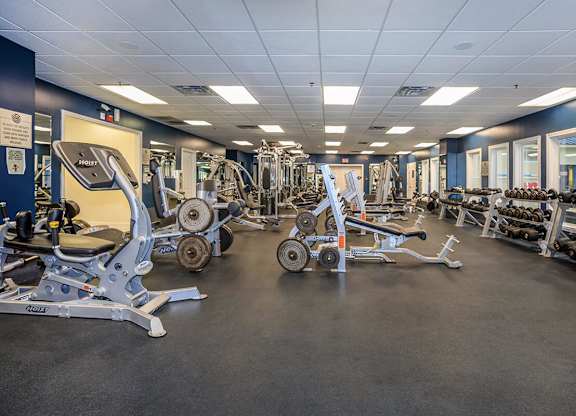 A gym with a variety of equipment including weights and machines.