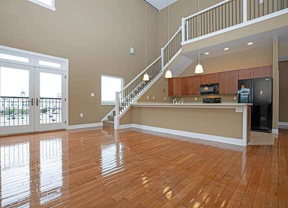 A spacious living room with a staircase leading to the upper floor.