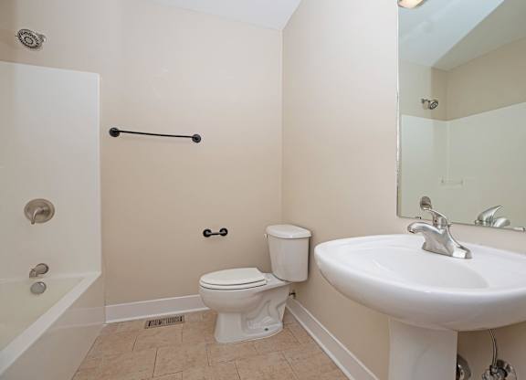 A white toilet sits next to a white sink in a bathroom.