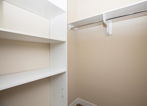 A white shelf is mounted on a wall.