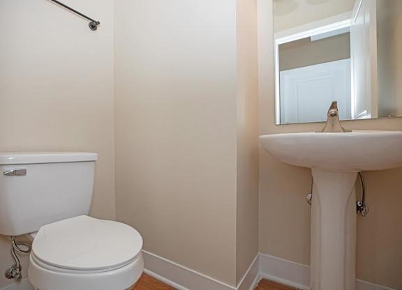 A white toilet and sink in a bathroom.