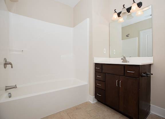 A white bathroom with a tub, sink, and toilet.