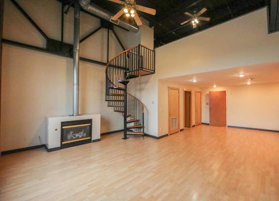 A room with a spiral staircase and a fireplace.