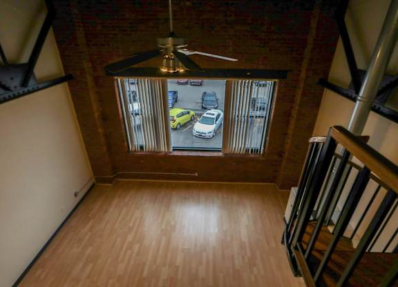 A view from the top of a staircase looking down at a parking lot.