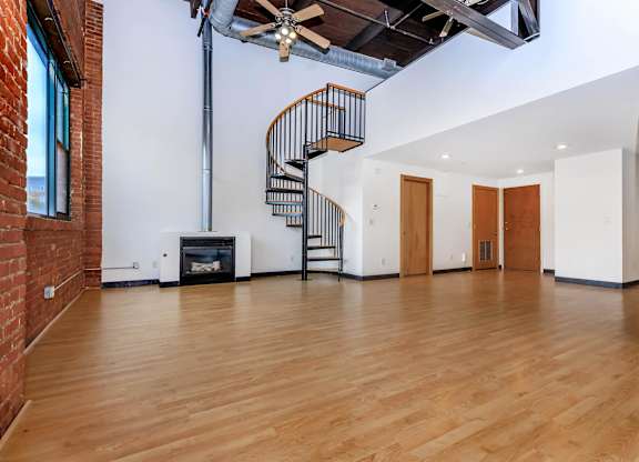 A room with a spiral staircase and a fireplace.