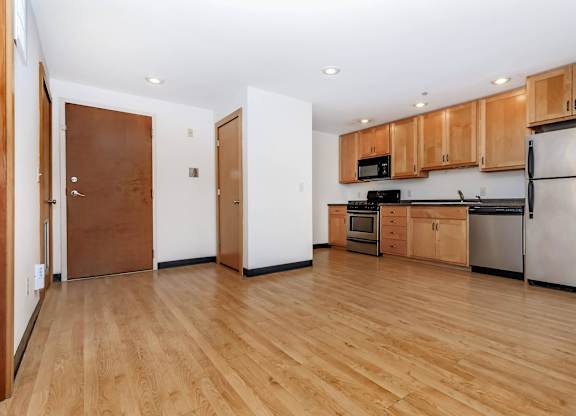 A kitchen with wooden floors and stainless steel appliances.