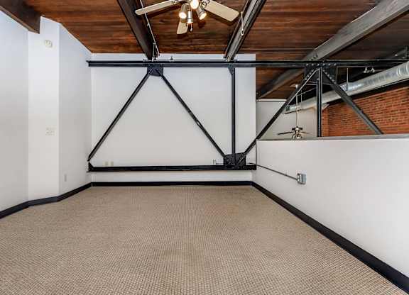 A room with a white wall and a brown carpet.