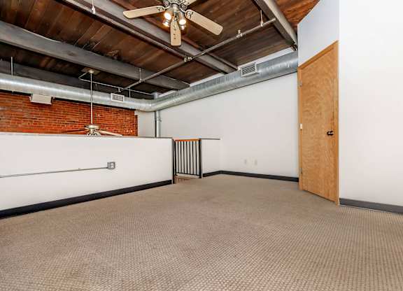 A room with a ceiling fan and a door.