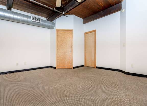 A room with two doors and a ceiling fan.