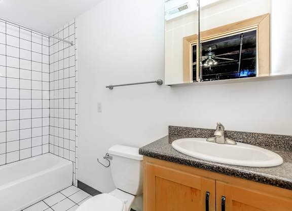 A bathroom with a white toilet, a white sink, and a white bathtub.