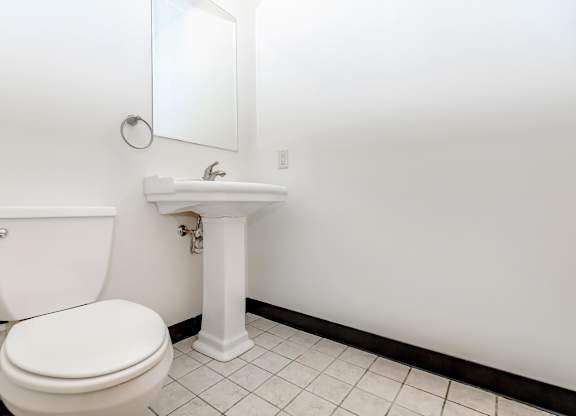 A white toilet and sink in a bathroom.