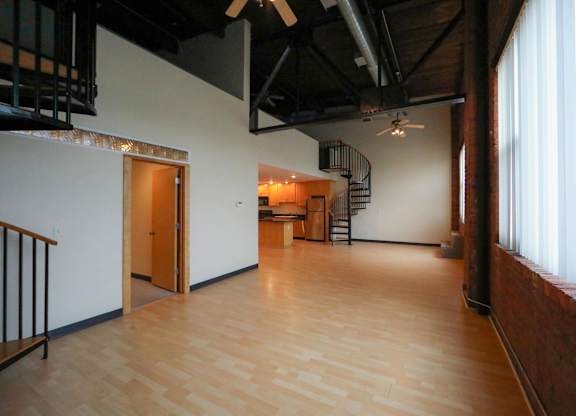 A room with wooden floors and a spiral staircase.