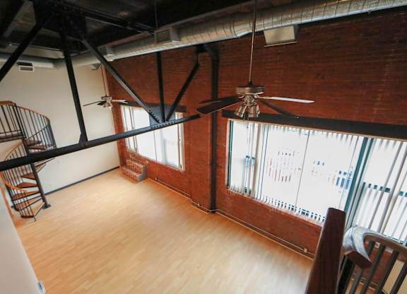 A room with wooden floors and a spiral staircase.