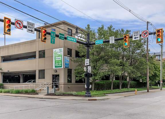 A street view with a building, traffic lights and signs.