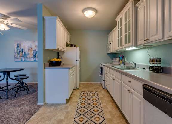 A kitchen with white cabinets and a black dishwasher.